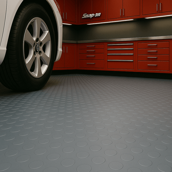 Close-up of car tire parked on grey round-dot rubber flooring in a garage with red tool cabinets; heavy-duty non-slip studded flooring provides traction and durability for garages and workshops; 2 m wide roll.