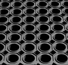 Close-up of heavy duty wet area mat with circular open-ring drainage pattern; non-slip rubber mat provides superior traction and water drainage in wet environments such as commercial kitchens, swimming pools and industrial facilities, measuring 1.5 m x 1 m and 23 mm thick.