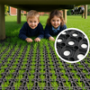 Children playing on Slip-Not rubber grass playground safety mats; 23 mm thick non-slip, weatherproof and eco-friendly mats with open-ring pattern for fall protection and mud control (BS EN 1177 certified)