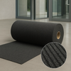 Rolled heavy-duty anthracite entrance mat in modern lobby; circular inset shows ribbed texture capturing dirt and moisture and improving traction; durable commercial barrier