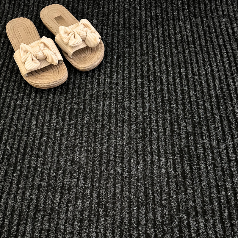 Close-up of anthracite triple-ribbed polypropylene barrier matting surface — 5.5mm pile height, 950g/m² weight