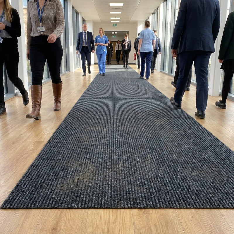 Anthracite barrier matting installed as corridor runner in UK commercial building — clean straight edges, no black border, triple-ribbed polypropylene