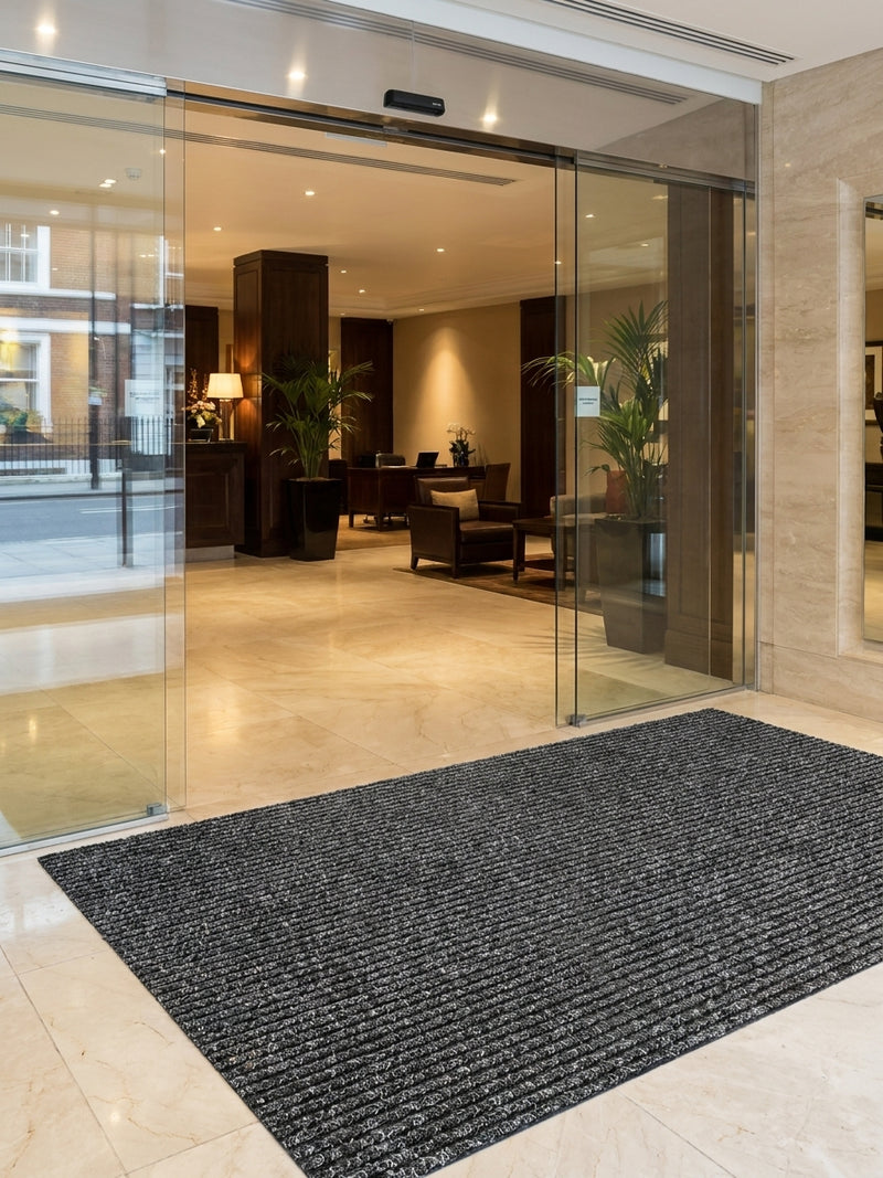 Anthracite barrier entrance matting at UK hotel entrance — triple-ribbed polypropylene mat, 8.5mm thick, commercial grade