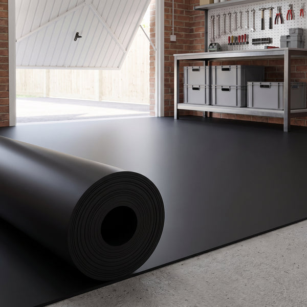 Plain black rubber flooring roll partly unrolled across a UK garage workshop floor