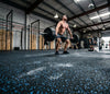 Blue fleck rubber gym matting roll in CrossFit box — black rubber base with blue EPDM flecks, seamless roll floor, Olympic lifting