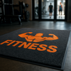 ChromaStep custom logo mat — gym and fitness studio entrance mat, bold orange logo on dark grey nylon