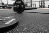 Close-up detail of black rubber gym flooring showing white EPDM fleck pattern