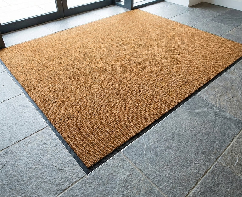 Natural coir matting installed flush in matwell — recessed into commercial building entrance floor, perfectly level with surrounding tiles