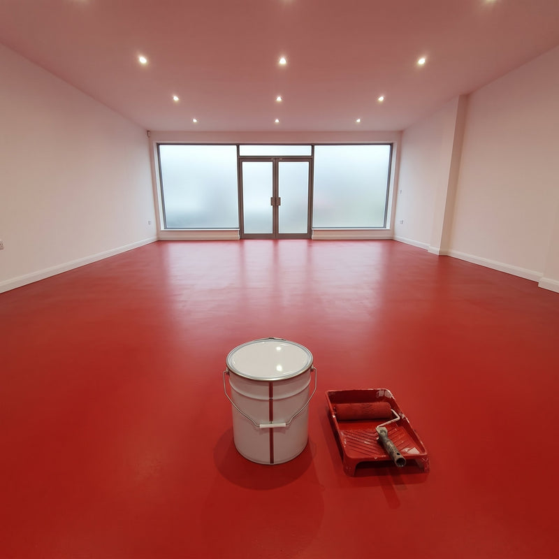 Bright red floor paint in an empty showroom with a frosted glass frontage, 20 litre tin and roller tray