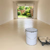 Cream floor paint in an empty home garage with the door open to the garden, 20 litre tin and roller