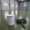 Dark green floor paint in an industrial unit with roller shutter doors, 20 litre tin and roller