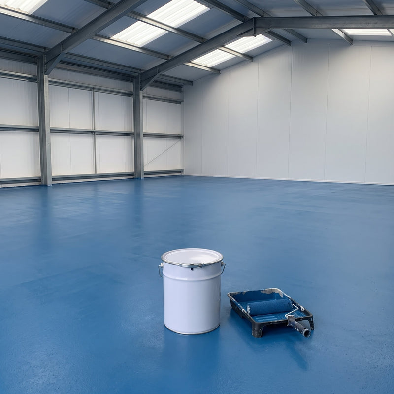 Light blue floor paint on an industrial unit floor, 20 litre tin and roller tray in the foreground
