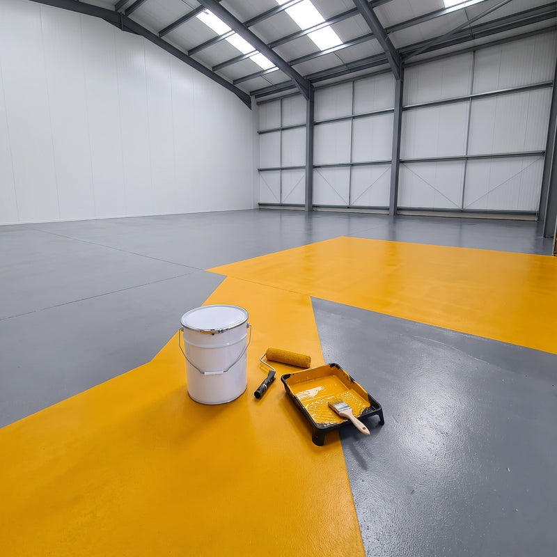 Yellow floor paint marking a walkway on a grey warehouse floor, 20 litre tin, roller and brush