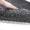 Hand lifting Slip-Not workstation rubber matting with open-circle holes and beveled edges; flexible anti-fatigue rubber mat demonstrates durability, drainage and easy handling for workstations and entrances. Measures 1.52 m x 0.91 m and 12.5 mm thick.