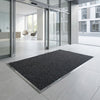 Anthracite polypropylene entrance matting installed flush in matwell — patterned fibre bonded sheet, 10mm thick, commercial building entrance
