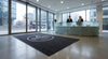 Custom branded logo mat at corporate office reception — digital print, exact Pantone colour matching, charcoal background with white logo