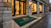 Custom logo mat at premium restaurant or boutique entrance — outdoor-rated UV-stable digital print, dark green with gold design