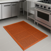 Oil-resistant nitrile workstation rubber mat under stove; orange perforated open-grid mat with beveled edges for drainage, cushioning and slip resistance, measuring 1.5 m x 0.9 m and 12.5 mm thick, ideal for kitchens and industrial workstations.