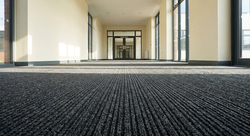 Dark anthracite fibre bonded entrance matting in UK school corridor — heavy duty, 2m and 4m wide, cut to length from 0.5m to 10m