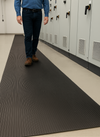 Class 2 electrical safety matting walkway with man walking through high-voltage control room; 17 kV rated, 4 mm thick, 1 m wide EPDM rubber walkway with fine-ribbed anti-slip surface for industrial electrical insulation