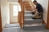 Carpet fitter fitting 12mm memory foam underlay to UK home staircase — foam on treads and risers, real installation in progress