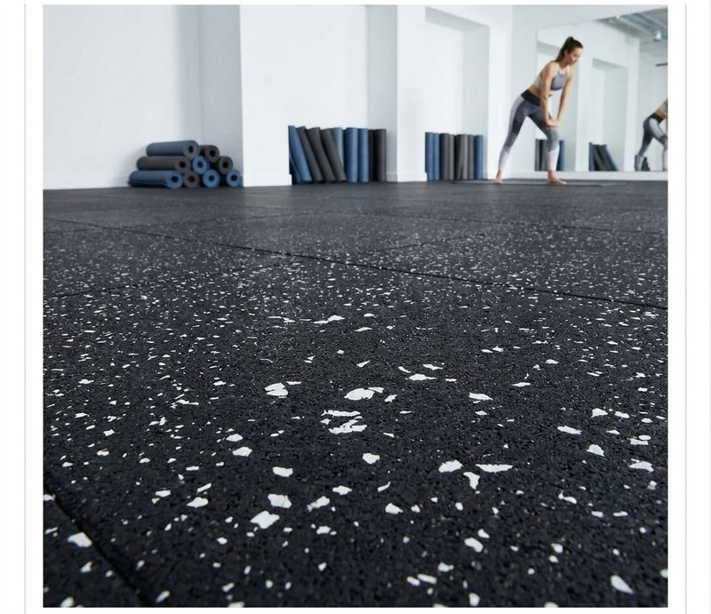 White fleck rubber gym matting roll in UK gym studio — black rubber base with white EPDM flecks, seamless roll floor